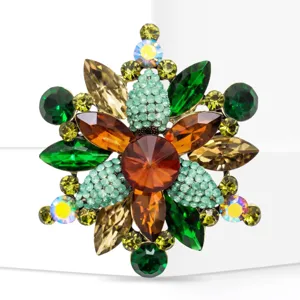Detailed shot of vintage multi-color gemstone crystal brooch, alloy gold tone, sparkling floral pin.