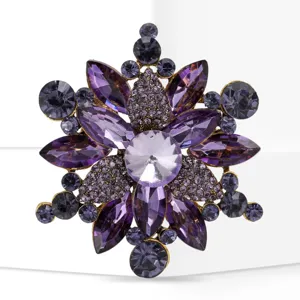 Close-up detail of a purple crystal flower brooch featuring sparkling rhinestones and gold-tone metal.