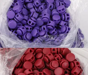 Colorful plastic double-hole cord locks detail view, spring toggle stoppers in bulk packs.