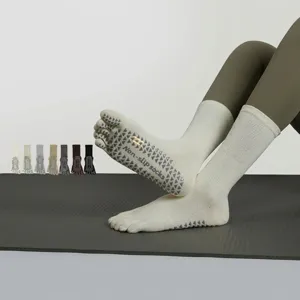 Close-up detail of women non-slip five-toe yoga socks with bottom grip dots for pilates workout.