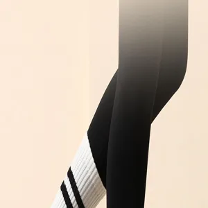 Gedetailleerd overzicht van antislip gestreepte yogasokken en zwarte leggings voor training.