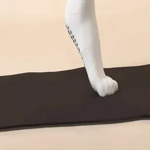 Detailopname van antislip yoga pilates sokken met zwarte gripnoppen op de zool voor extra grip.