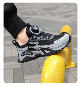 Close-up of kids running shoes with rotary dial button and mesh breathable upper detail.