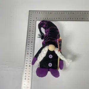 Nahaufnahme von Halloween Zwerg Plüschtier Puppe mit schwarzem lila Hexenhut und Zöpfen.