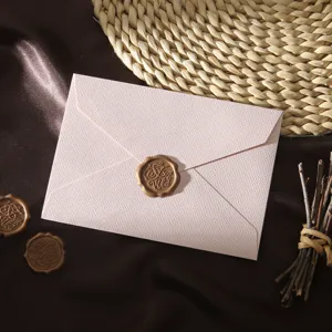 Enveloppe texturée rose avec sceau de cire doré, élégant détail de papeterie vintage.