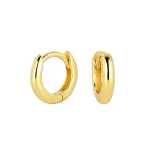 Vue rapprochée détaillée de boucles d'oreilles créoles en argent sterling doré surface lisse.