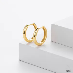 Gros plan détaillé de boucles d'oreilles créoles dorées lisses 12mm, bijou épuré.