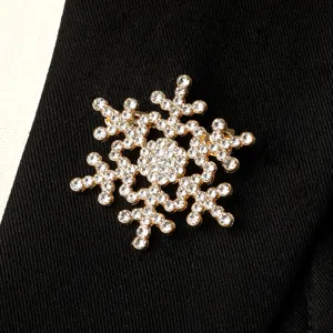 Exquisite crystal rhinestone snowflake brooch pin, elegant gold tone winter jewelry accessory.