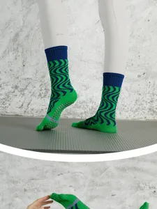 Detailed view of non-slip five-toe yoga socks with wave pattern and grip soles for fitness.