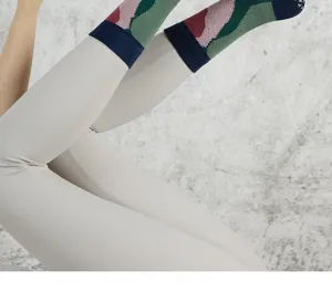 Detail shot of non-slip athletic yoga socks and leggings in cozy indoor studio setting.