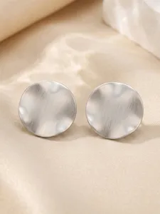 Vue détaillée de boucles d'oreilles clous irrégulières en acier inoxydable brossé argent.