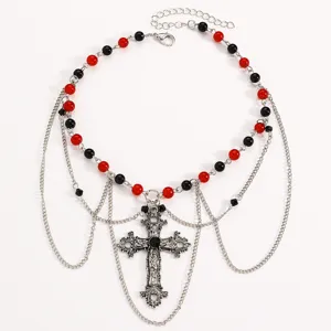 Collana a croce multistrato vintage gotica scatto di dettaglio con perle nere rosse e catene.