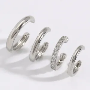 Set de cuatro aretes de oreja plateados en C, estilos pulidos lisos y con pedrería brillante.