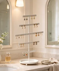 Detail view of white metal jewelry display stand with multi tiers on marble countertop.