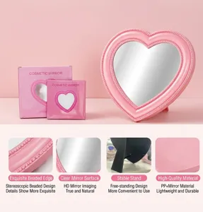 Heart-shaped desktop makeup mirror with cute pink frame, clear glass and stable stand detail.