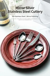 Mirror silver stainless steel cutlery set with elegant vintage handles, luxury tableware.