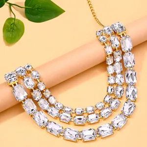 Collana girocollo multistrato con scintillanti cristalli e dettagli di catena dorata.