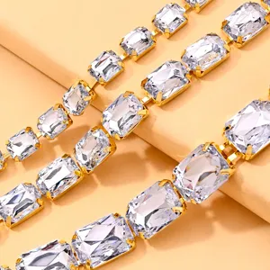 Primo piano dettagliato di collana con catena in strass multistrato e cristalli rettangolari dorati.
