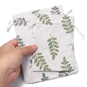 Detail shot of linen drawstring pouches featuring a natural green leaf print and clean texture.