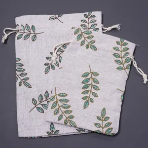 Linen drawstring pouch with green leaf print, durable fabric storage bag for small items.