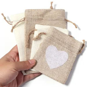 Detail view of natural linen drawstring pouch bags with cute heart print for jewelry storage.