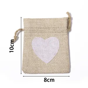 Close-up detail view of the rustic burlap drawstring pouch featuring a white heart print.