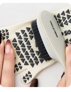 Detail view of anti-slip five-finger yoga socks with black grip dots and cleaning tool.
