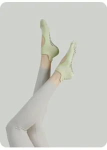 Detail view of light green non-slip pilates yoga socks with grip sole and strap design.