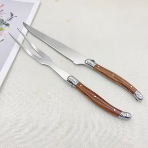Ensemble couteau et fourchette à découper en acier inoxydable avec manche en bois.