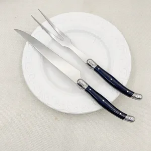 Ensemble couteau et fourchette à découper en acier inoxydable avec manche noir.