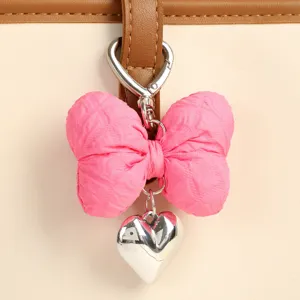 Porte-clés nœud en tissu rose avec pendentif cœur argenté, joli grigri de sac et accessoire.