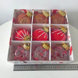 Vista detallada de 9 bolas de navidad en caja festiva con regla de referencia de tamaño.