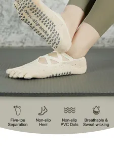 Detailed view of women non-slip pilates yoga five-toe socks with cross straps and grip soles.