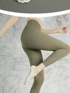 Close-up of non-slip yoga toe socks with crisscross straps and flexible leggings detail.