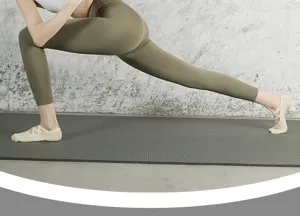Details showing grip yoga socks with straps worn during fitness stretching exercises on mat.