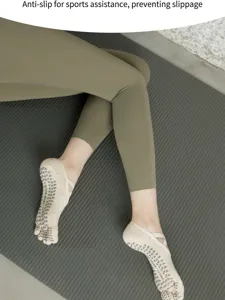Detail shot of women's five-toe grip socks with strap design on yoga mat for fitness.