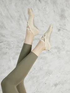 Non-slip grip pilates yoga socks with cross straps for women indoor fitness training detail.