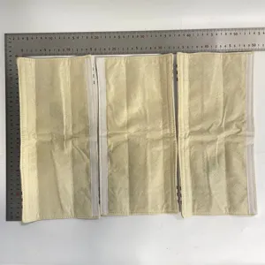 Nahaufnahme von cremefarbenen Stoff-Gerätegriffbezügen mit Klettverschluss und Maßstab.