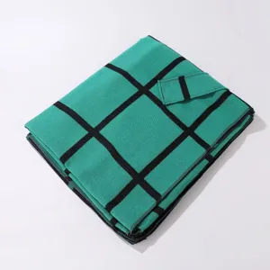 Detailed view of the green and black plaid split cape shawl with side strap design for autumn.