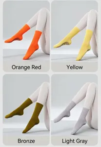 Detailed view of solid color grip yoga socks in orange, yellow, bronze, and light grey.