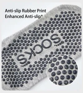 Detailed view of grey yoga socks featuring anti-slip silicone dot grips and text pattern.