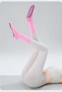 Close-up detail showing the non-slip grip dots on the sole of pink yoga fitness socks.