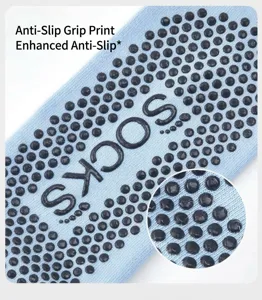 Detailed view of light blue non-slip yoga socks featuring dense black grip dots inside.