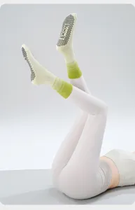 Gradient green non-slip yoga socks detail with black grip dots on sole for pilates.