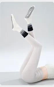 Detail view of anti-slip yoga socks featuring black gradient cuffs and dotted grips on sole.