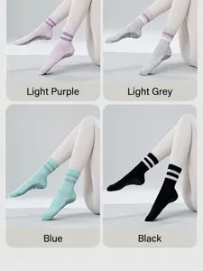 Detailed view of non-slip yoga socks with dot grip soles and striped cuffs in multiple colors.