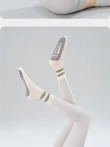 Detailed view of women non-slip yoga socks with grip dots and green ankle stripes.
