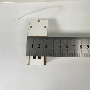 Detailed view of the mini wooden Christmas house ornament showing its size with a small ruler.