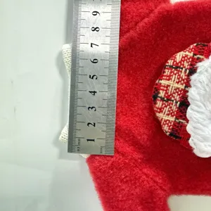 Dettaglio della copertura per bottiglia di vino di Natale con tessuto rosso e righello.