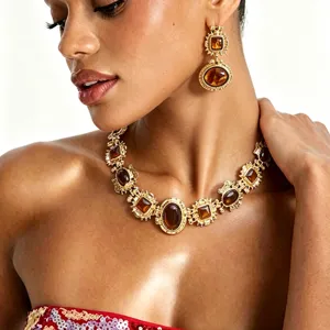 Gros plan détaillé d'un collier style baroque doré et de ses boucles d'oreilles assorties.